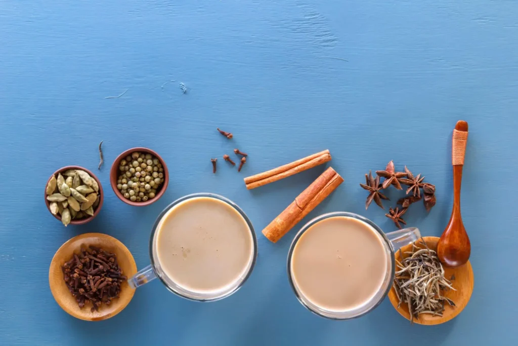 Chai latte ingredients including black tea, cinnamon, cardamom, ginger, cloves, and milk