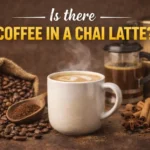 A steaming cup of chai latte with coffee beans and spices showing the concept of coffee in a chai latte