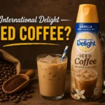 International Delight Vanilla Iced Coffee bottle with iced coffee glass, coffee beans, and rustic background
